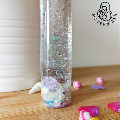 Comprar botella sensorial liquida de la calma Conchas y  Perlas basada en el método Montessori para estimular los sentidos y el desarollo motor, emocional e intelectual de los bebés y de los niños. 